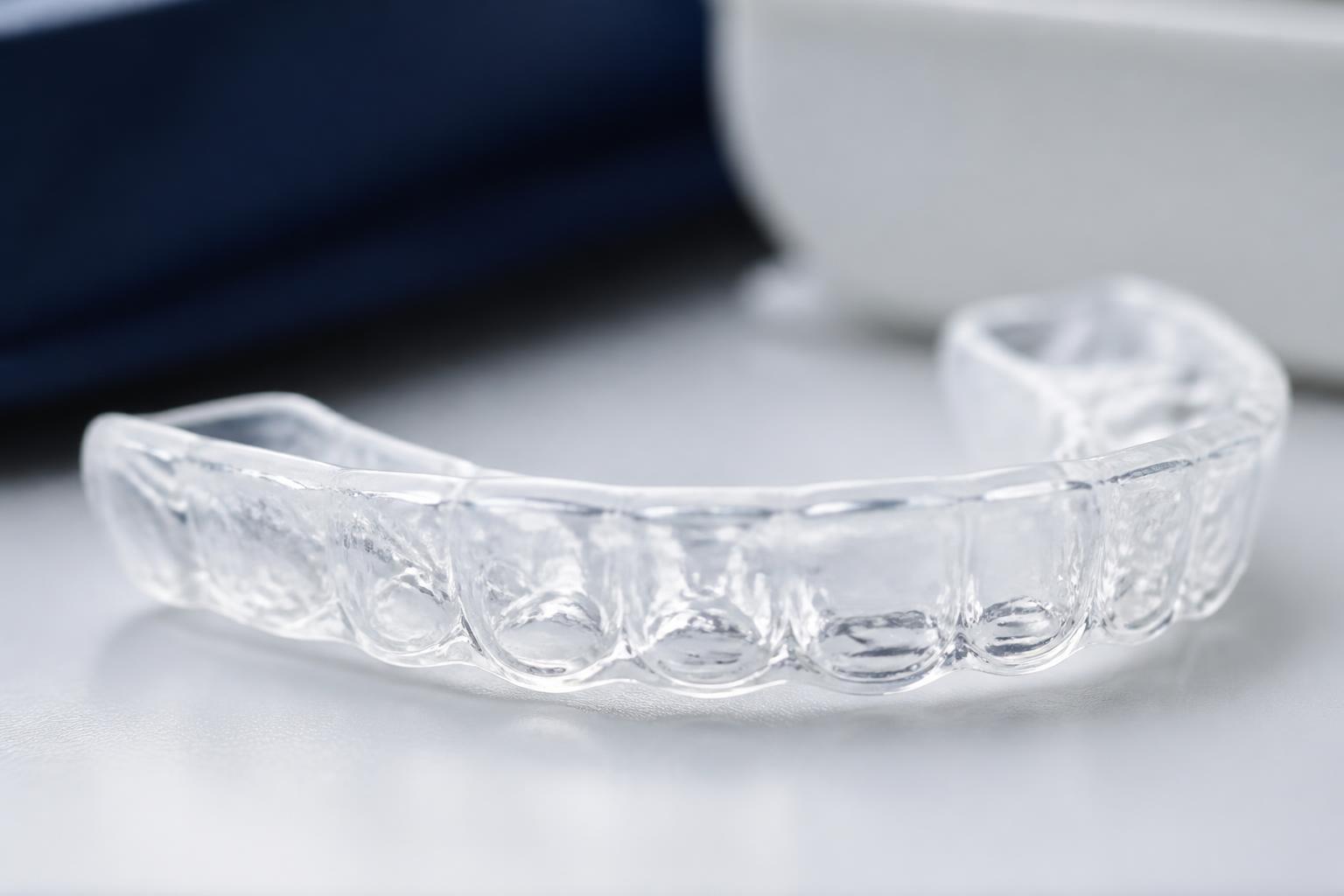 Moldeira transparente de clareamento dental com gel sobre superfície clara